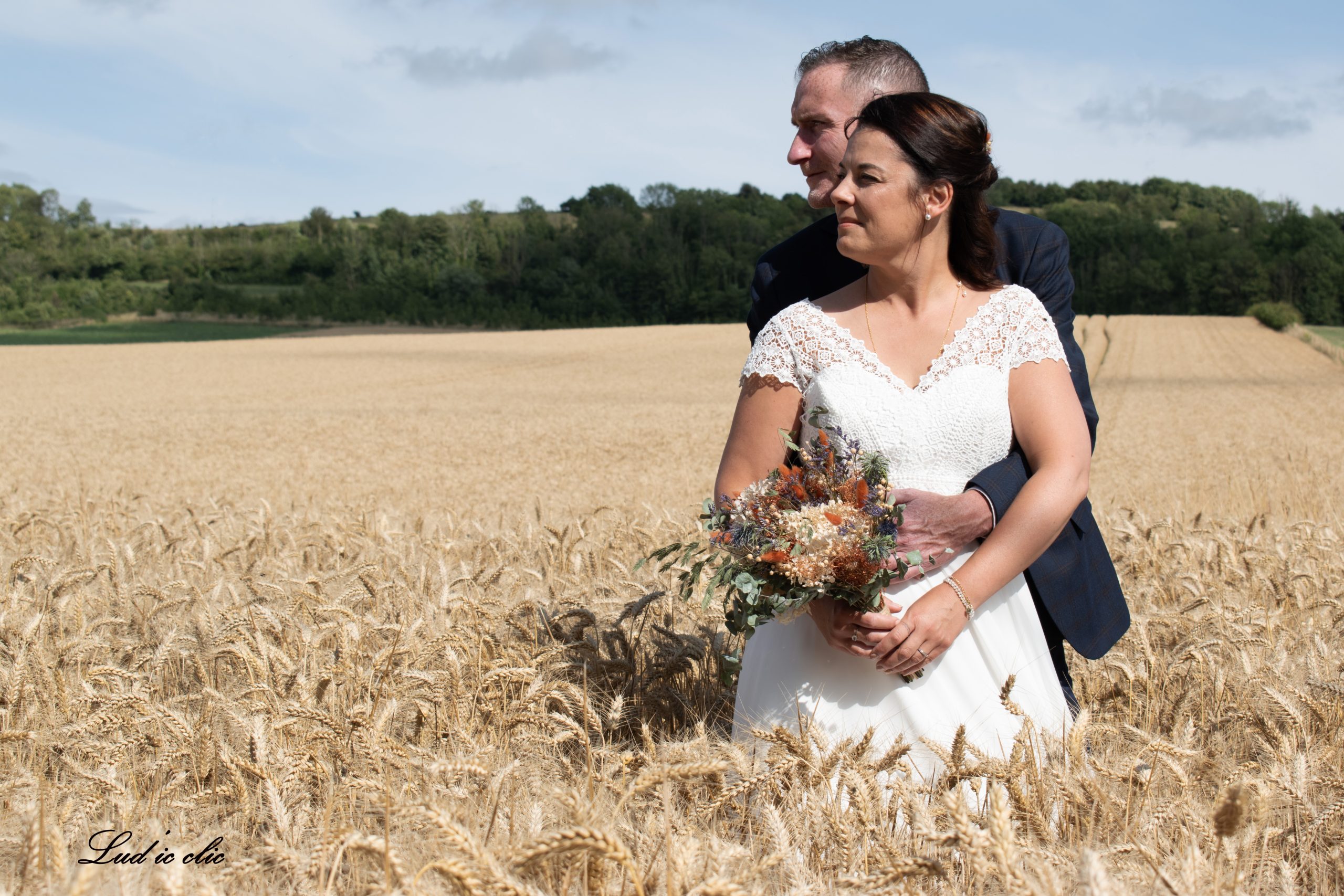 photo des mariés dans un champ de blé