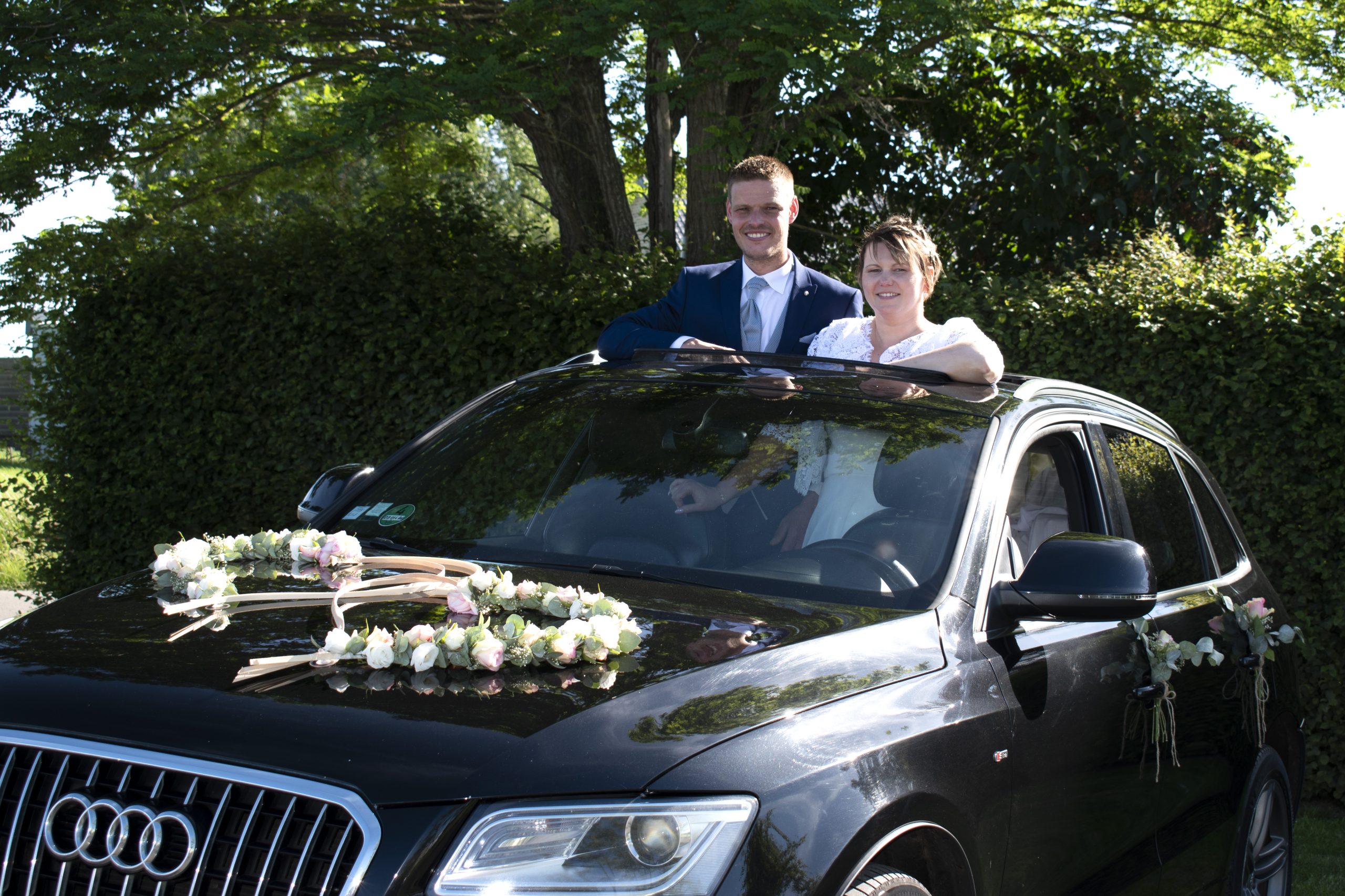 les mariés posent dans leur voiture, amour joie naturel 