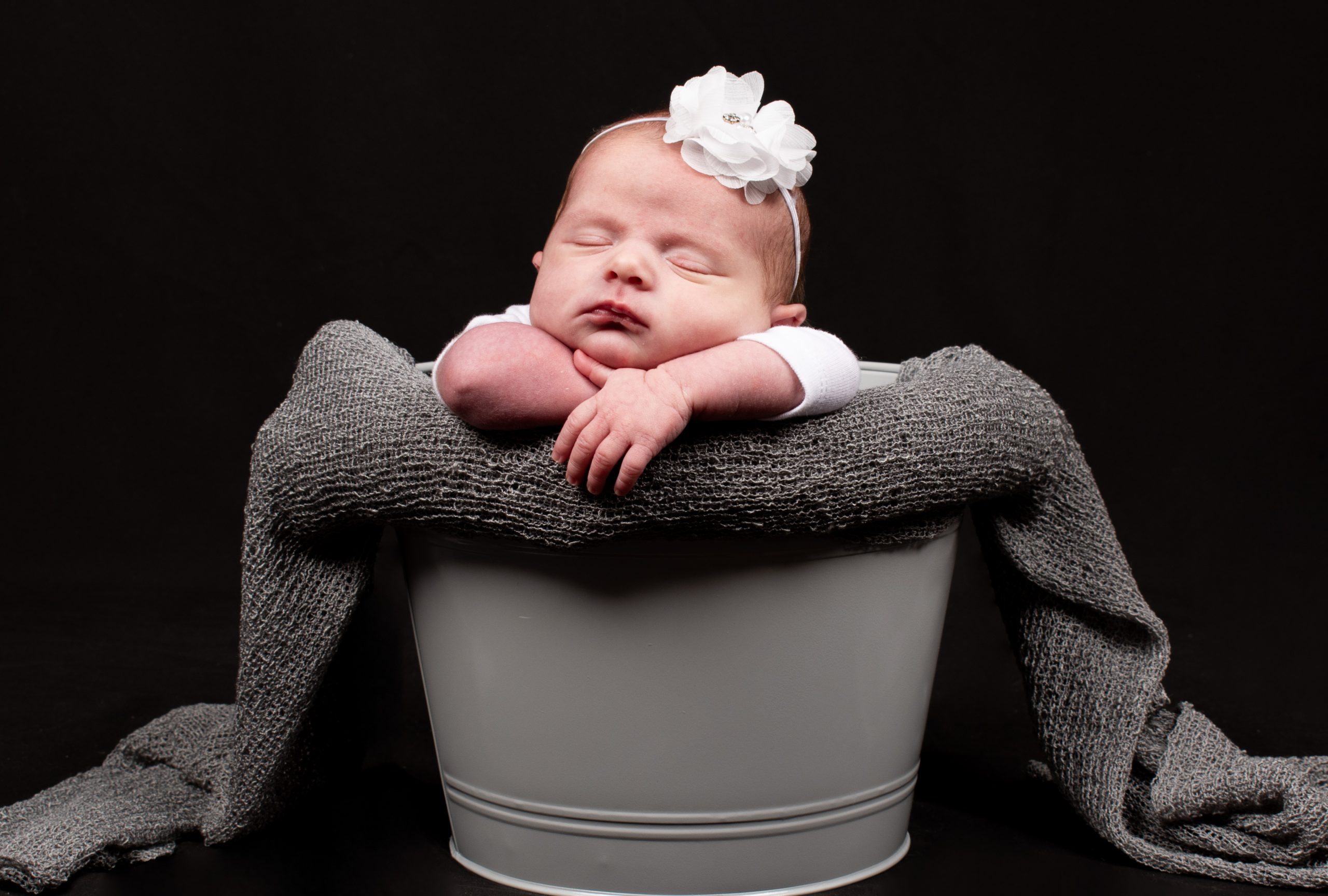 bébé prend la pose dans  un seau 