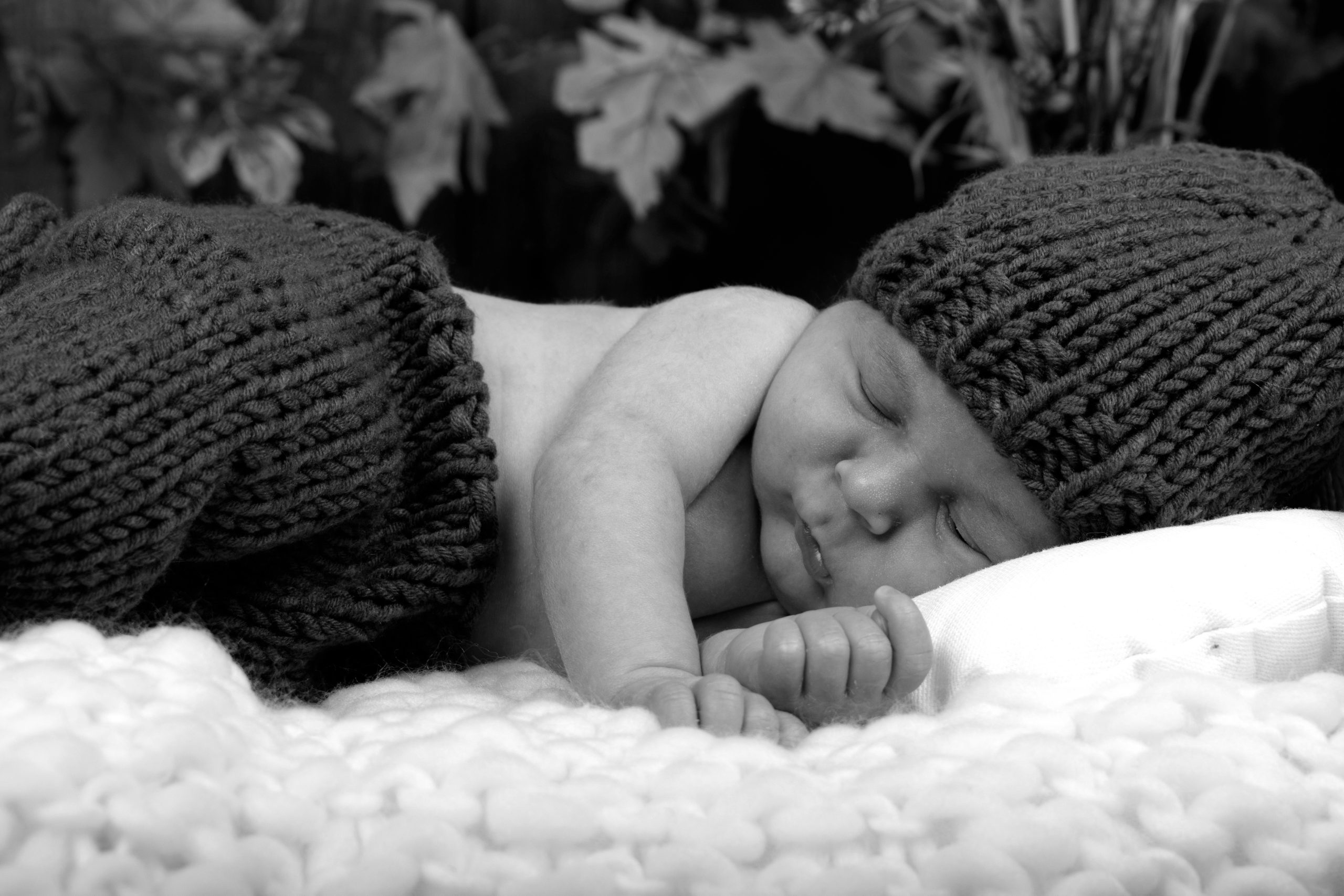 bébé qui dort dans un lit en shooting naissance au home studio