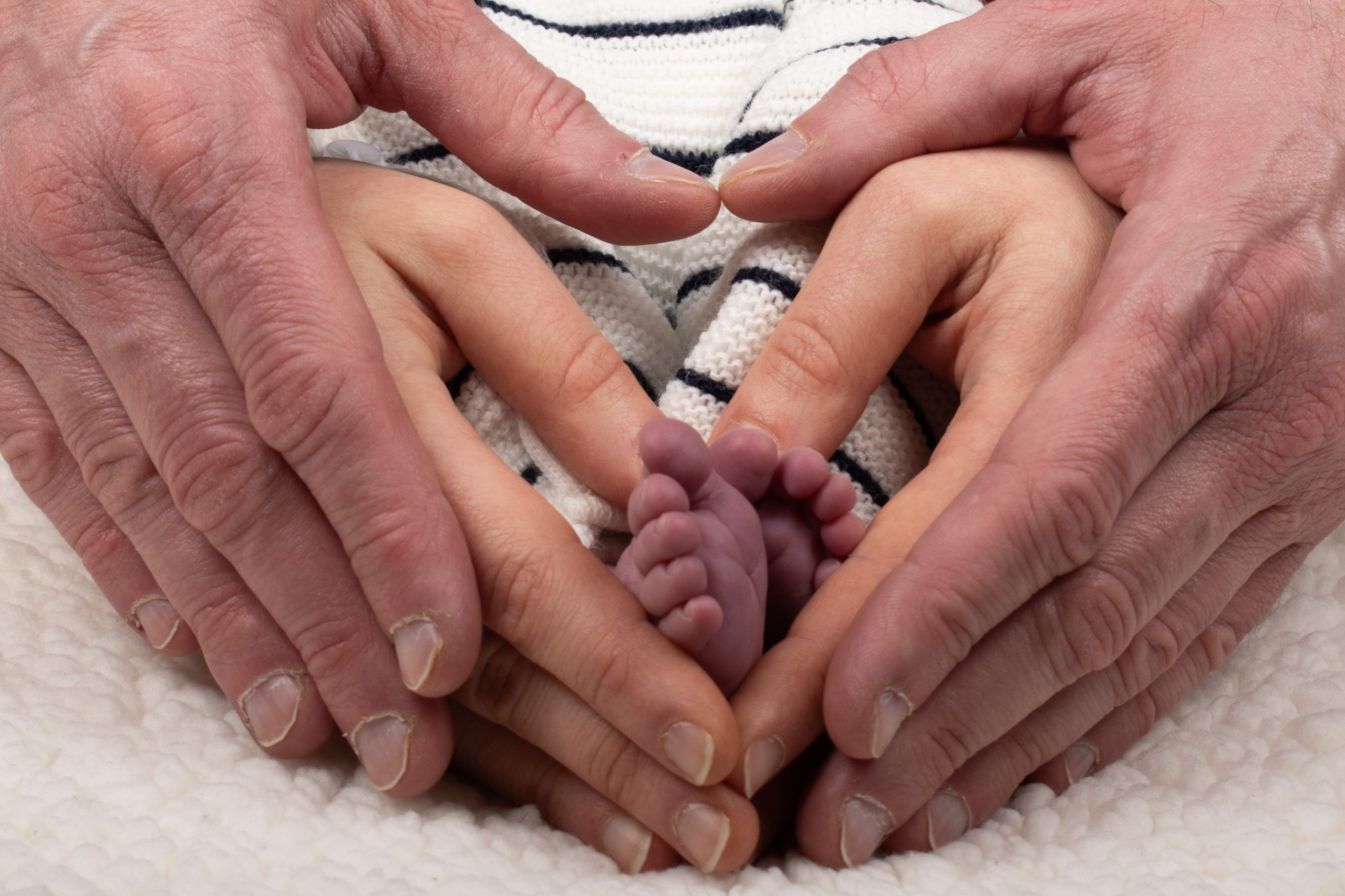 mains de papa et maman et pieds de bébé